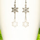 Long Chain and Snowflakes Charm Earrings displayed on a coffee mug.