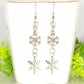 Long Chain and Snowflakes Charm Earrings displayed on a tea cup.