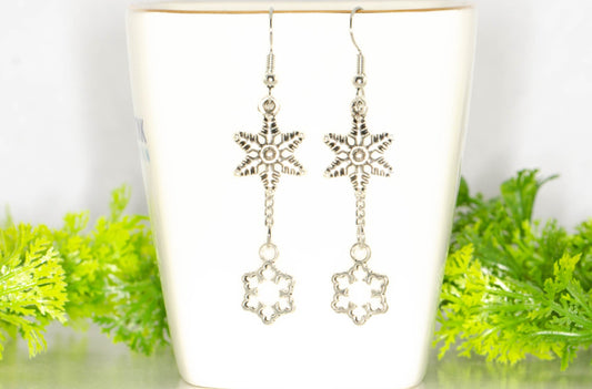 Long Chain and Snowflakes Charm Earrings displayed on a tea cup.