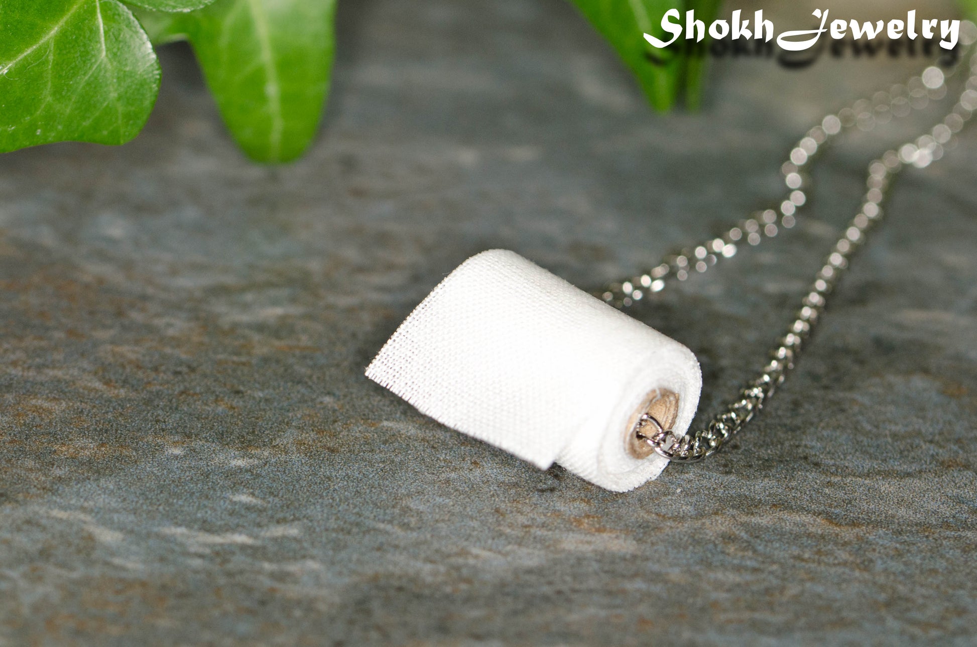 Close up of Miniature Toilet Paper Roll Necklace.