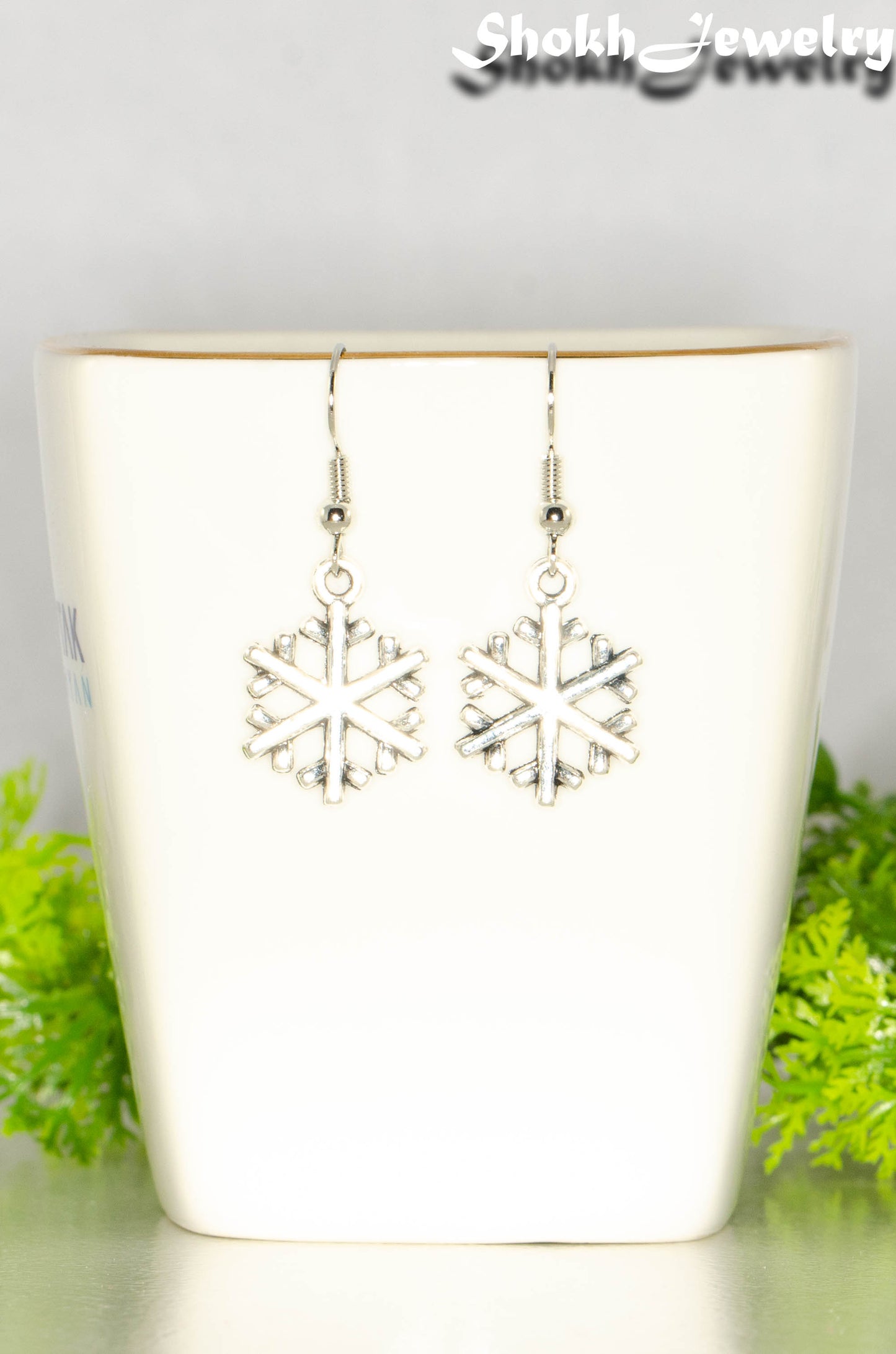 Close up of Christmas Snowflakes Charm Earrings.