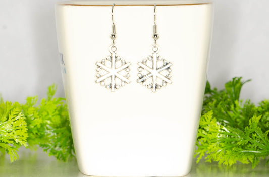 Christmas Snowflakes Charm Earrings displayed on a tea cup.