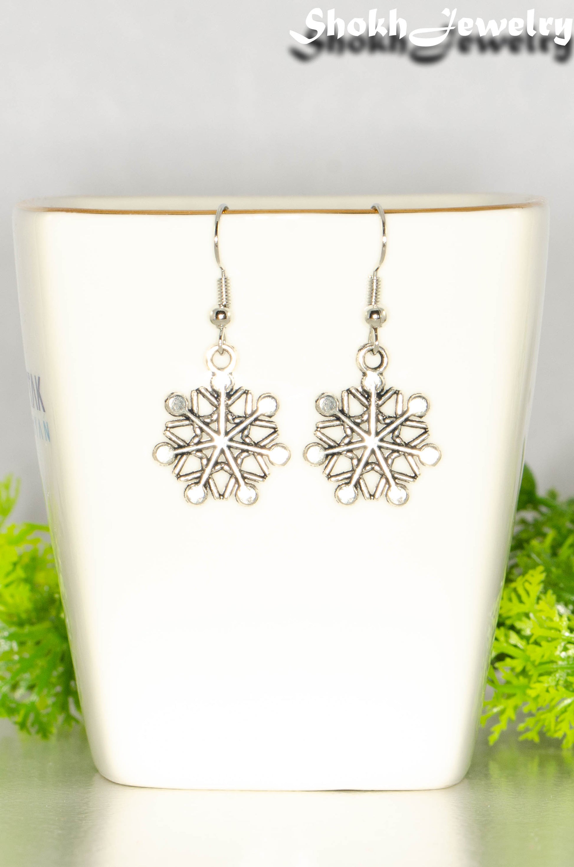 Close up of Christmas Snowflakes Charm Earrings.