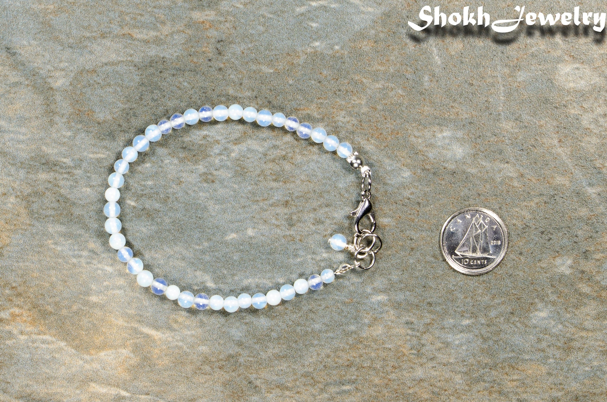 4mm White Opal anklet with Clasp beside a dime.