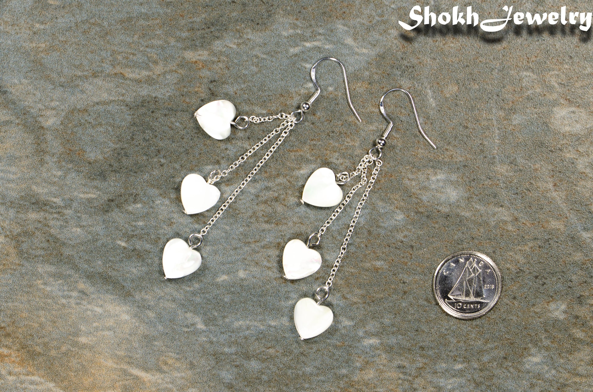 Long Silver Plated Chain and Seashell Heart Earrings beside a dime.