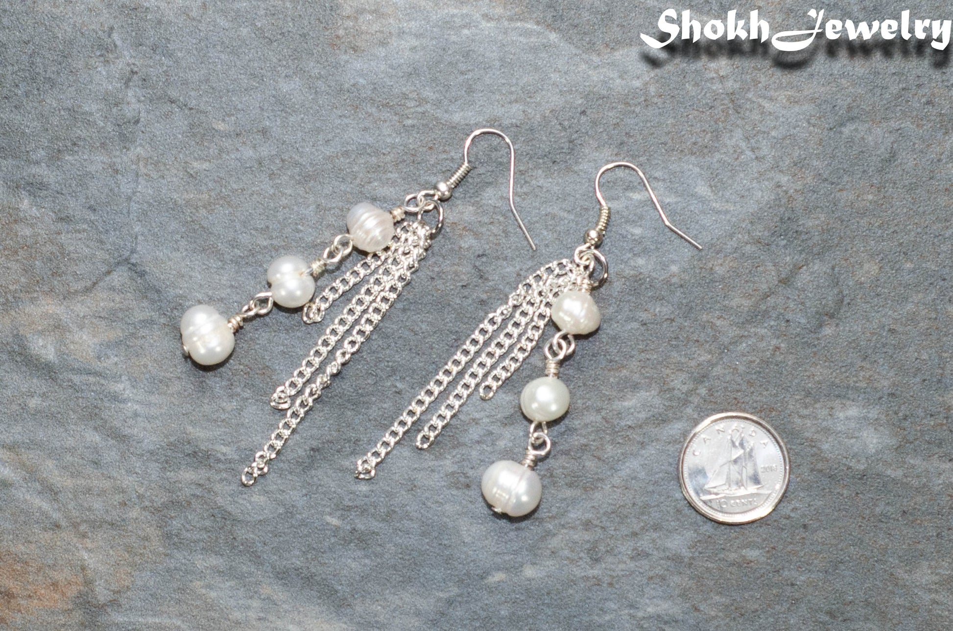 Long Chain and Freshwater Pearls Earrings beside a dime.