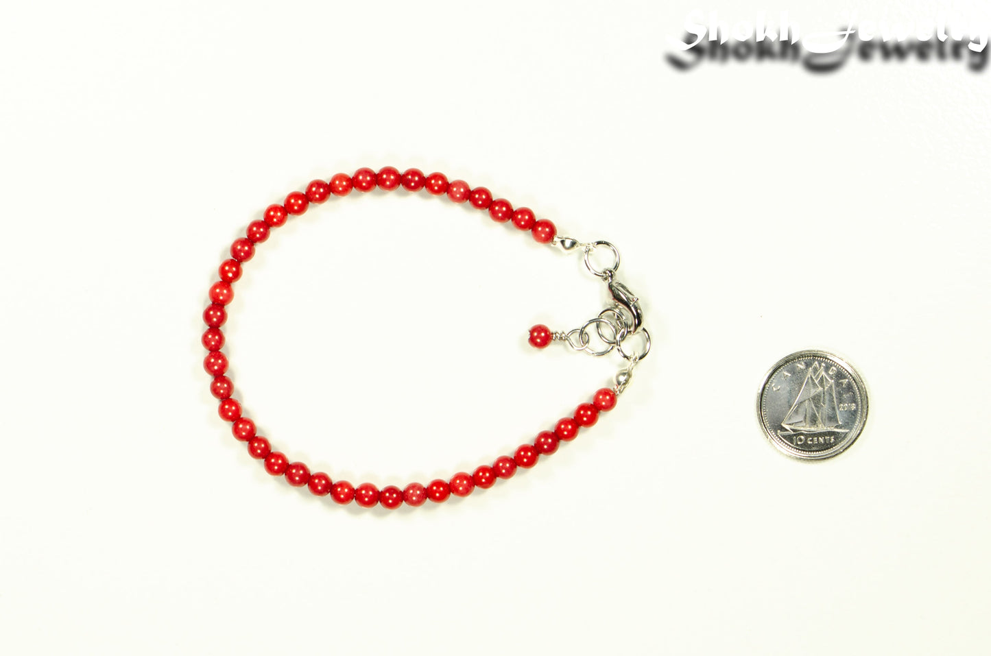 4mm Natural Red Coral anklet with Clasp beside a dime.