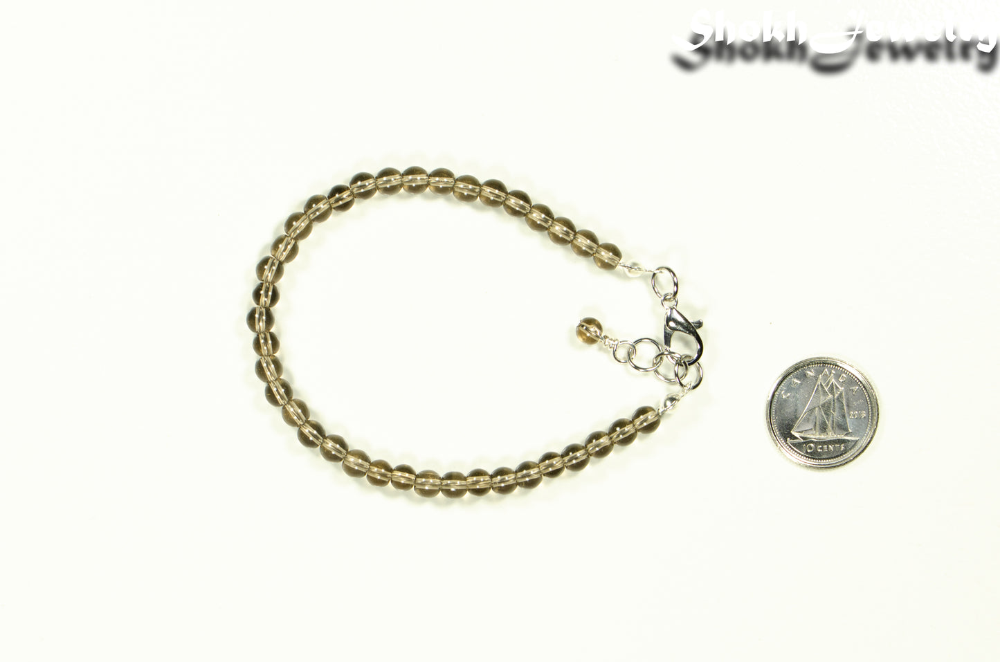 4mm Smoky Quartz Bracelet with Clasp beside a dime.