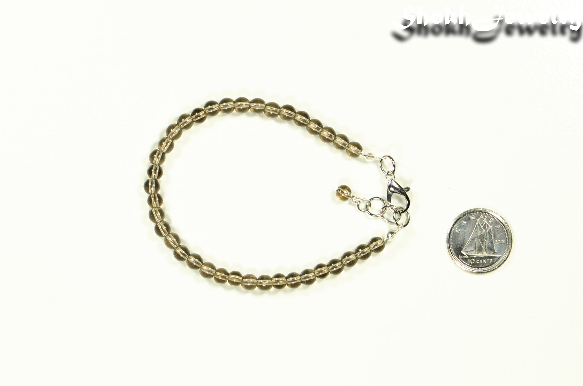 4mm Smoky Quartz Bracelet with Clasp beside a dime.