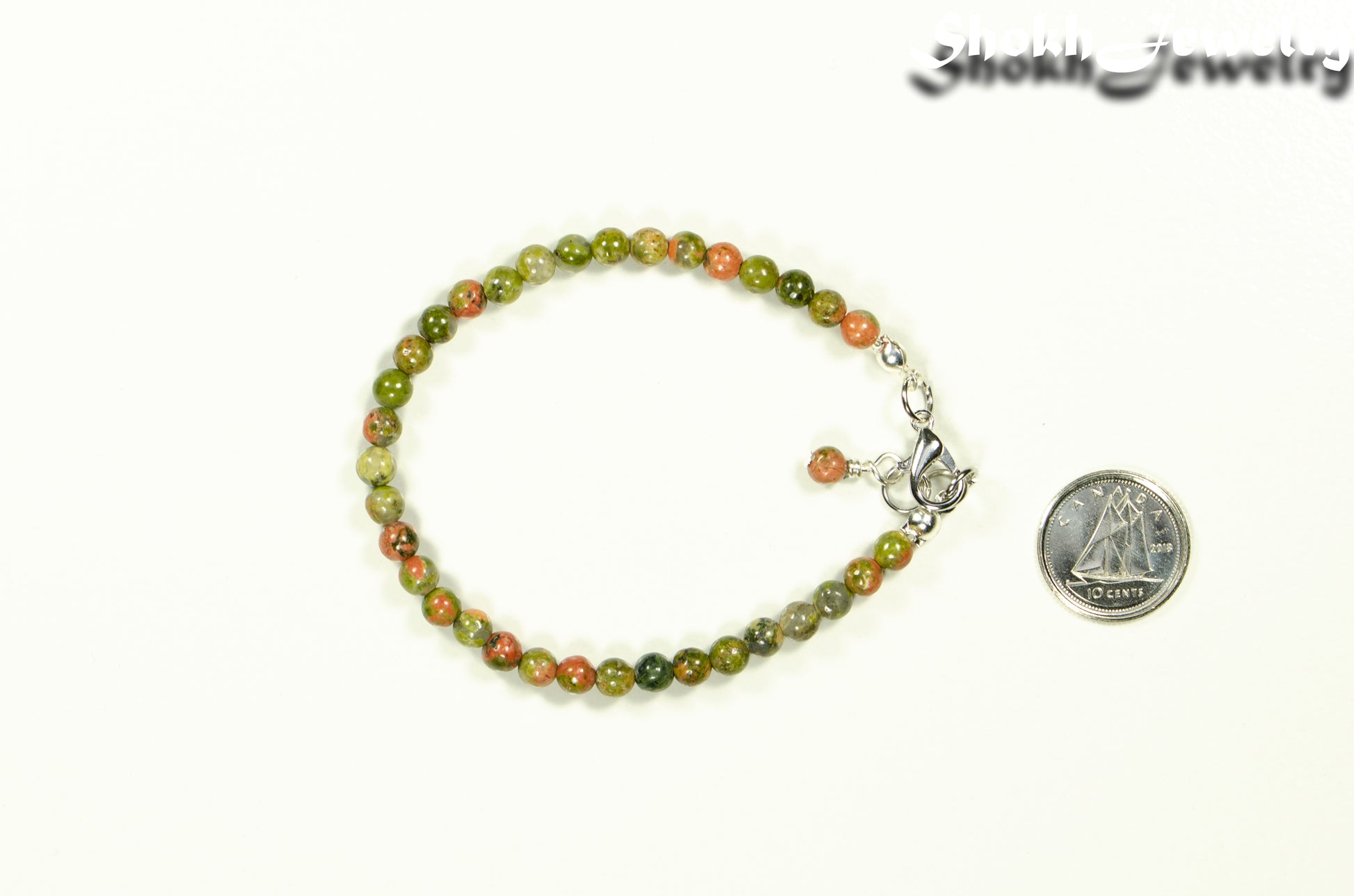 4mm Natural Unakite Bracelet with Clasp beside a dime.