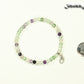 4mm Rainbow Fluorite Bracelet with Initial beside a dime.