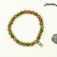 6mm Unakite Bracelet with Initial beside a dime.