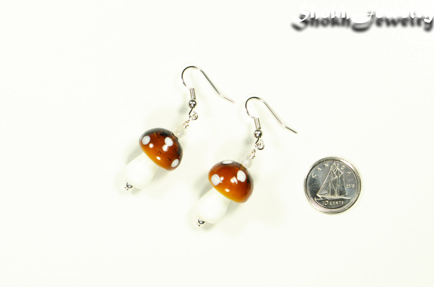 Brown Mushroom Glass Bead Earrings beside a dime.