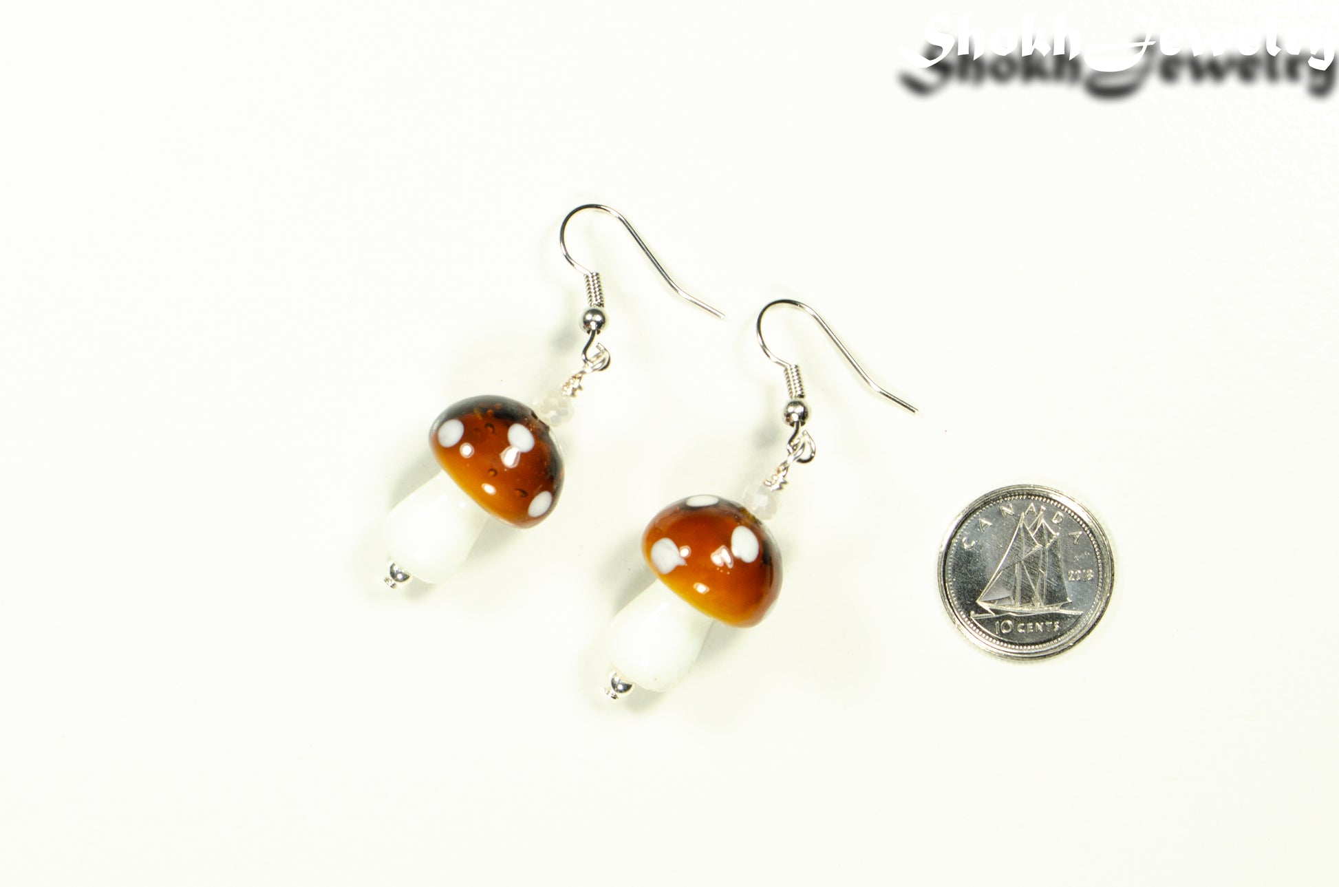 Brown Mushroom Glass Bead Earrings beside a dime.