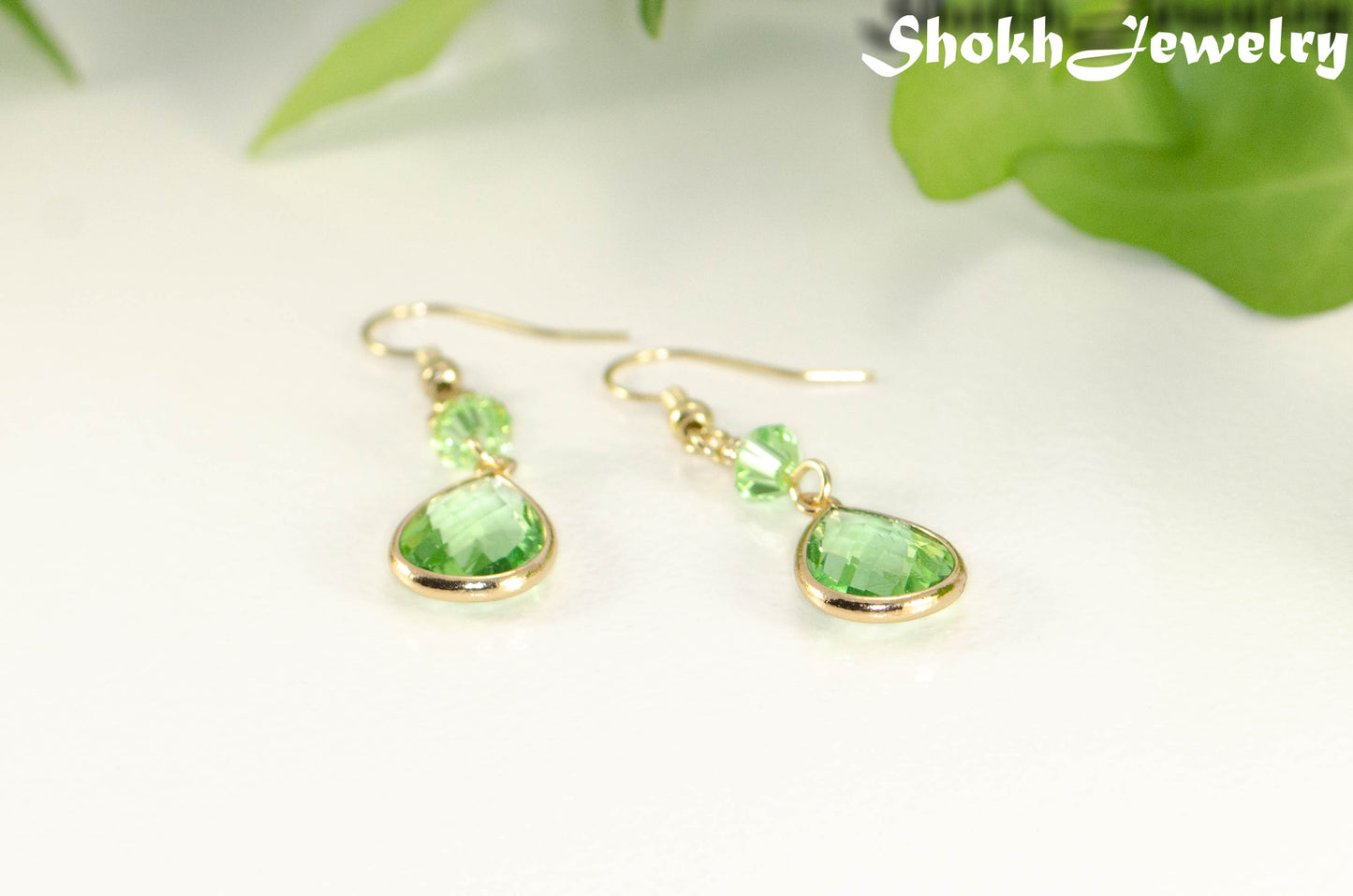 Green Glass Teardrop Dangle Earrings with gold tone ear wires.