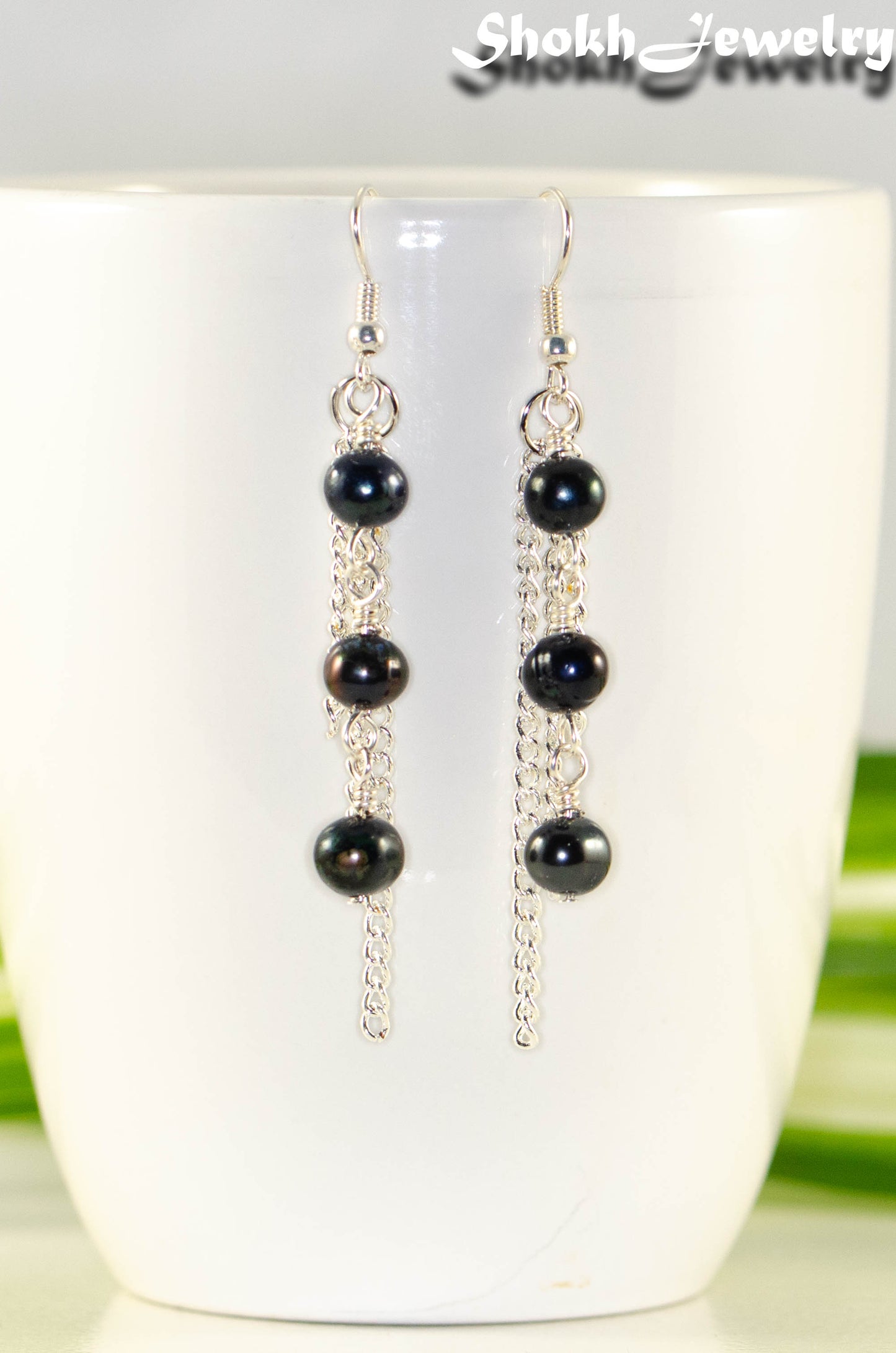 Close up of Long Chain and Black Freshwater Pearls Earrings.