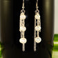 Close up of Long Chain and Freshwater Pearls Earrings.