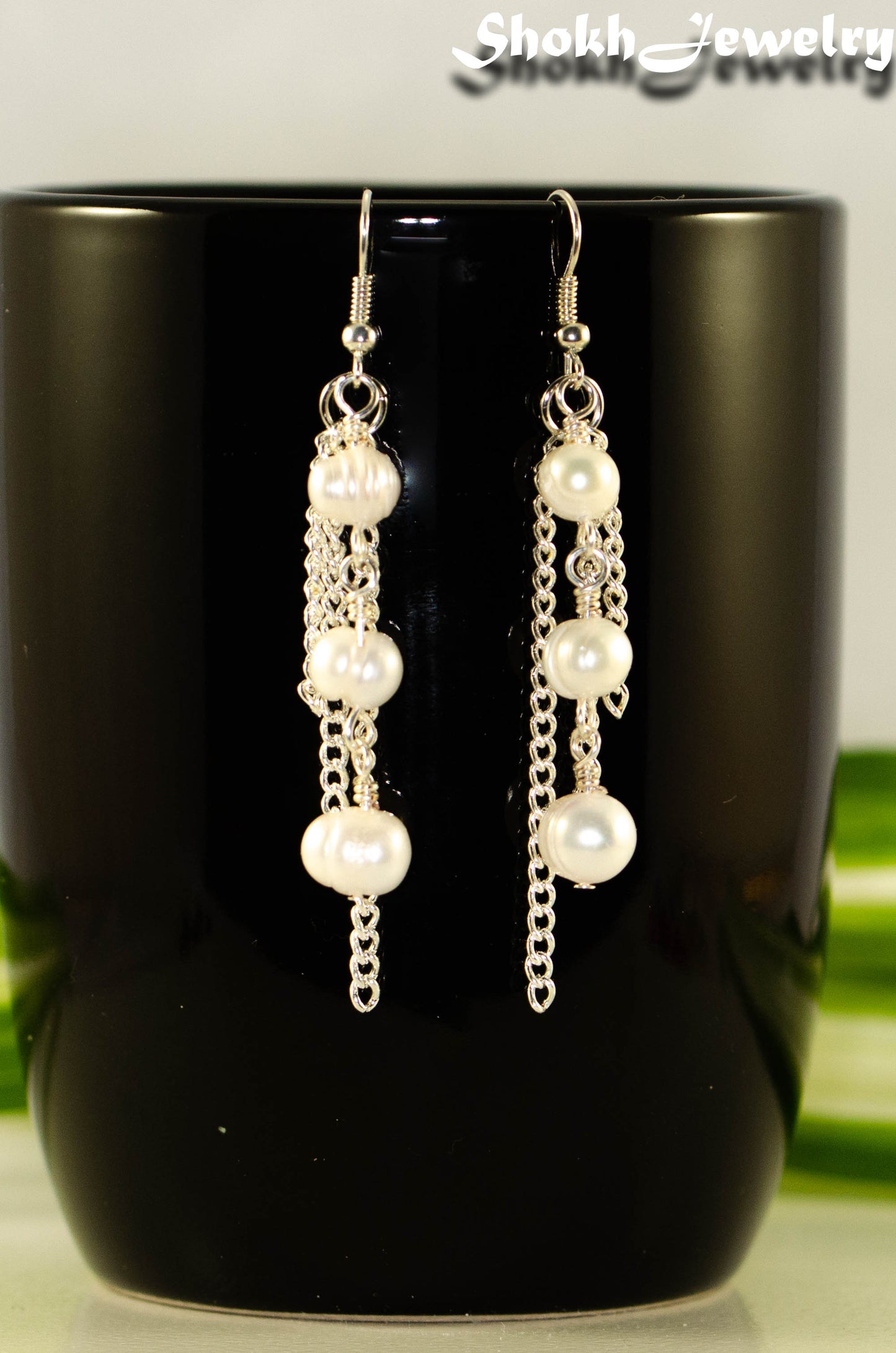 Close up of Long Chain and Freshwater Pearls Earrings.