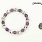 Amethyst and Purple Flower Ceramic Bead Bracelet besude a dime.