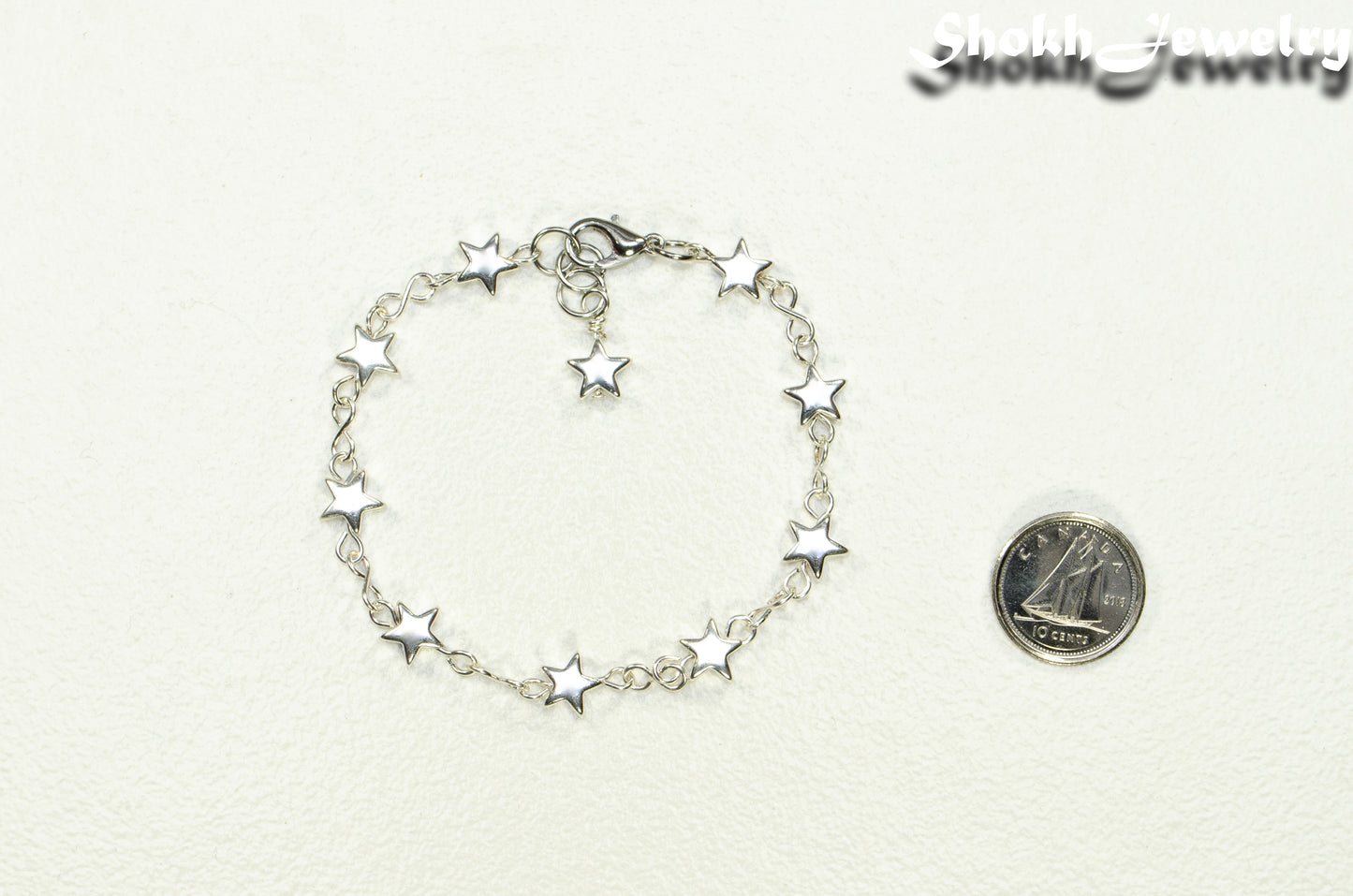 Silver plated Hematite Star Link Bracelet beside a dime.