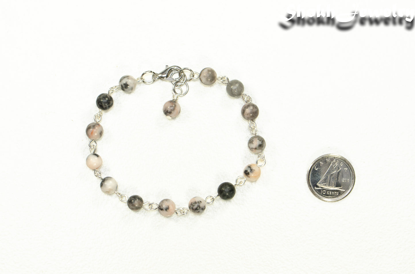 Handmade Pink Zebra Jasper Link Bracelet beside a dime.