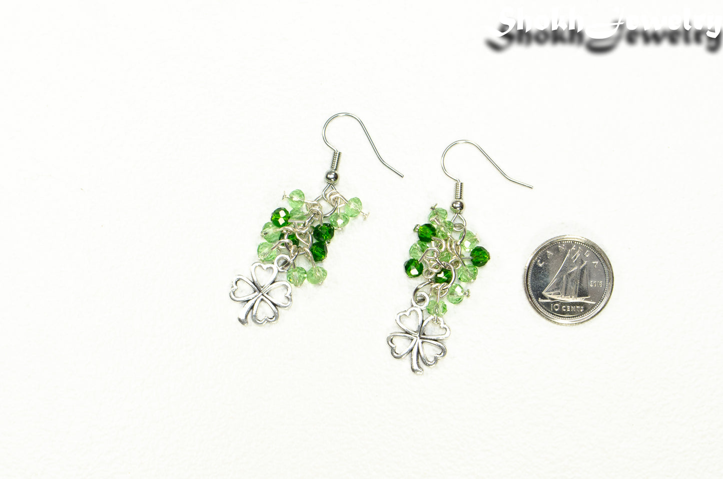 Lucky Four Leaf Clover Charm and Green Glass Bead Earrings beside a dime.