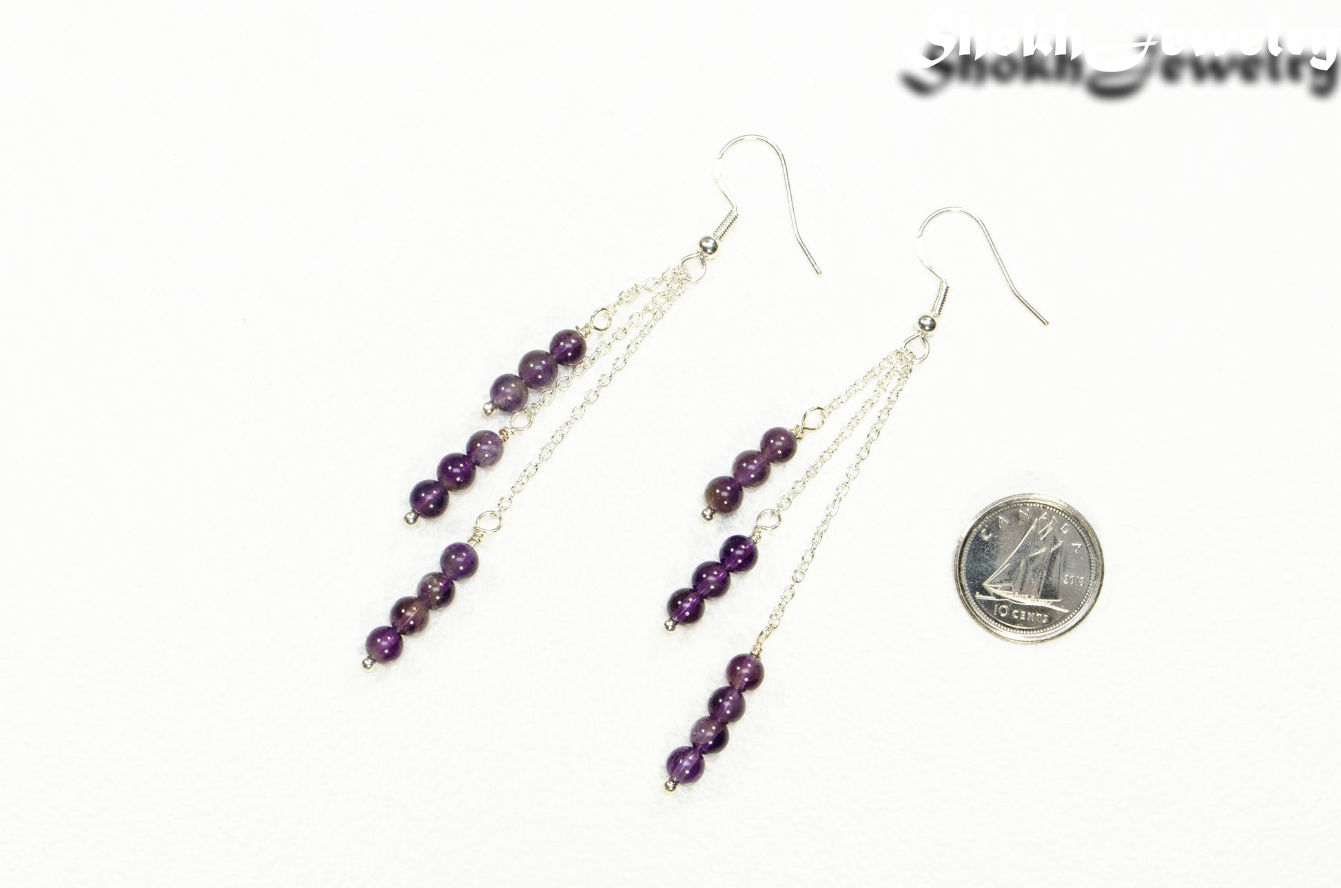 Silver Plated Chain and Amethyst Crystal Earrings beside a dime.