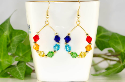 Rainbow Glass Crystal Hoop Earrings displayed on a tea cup.