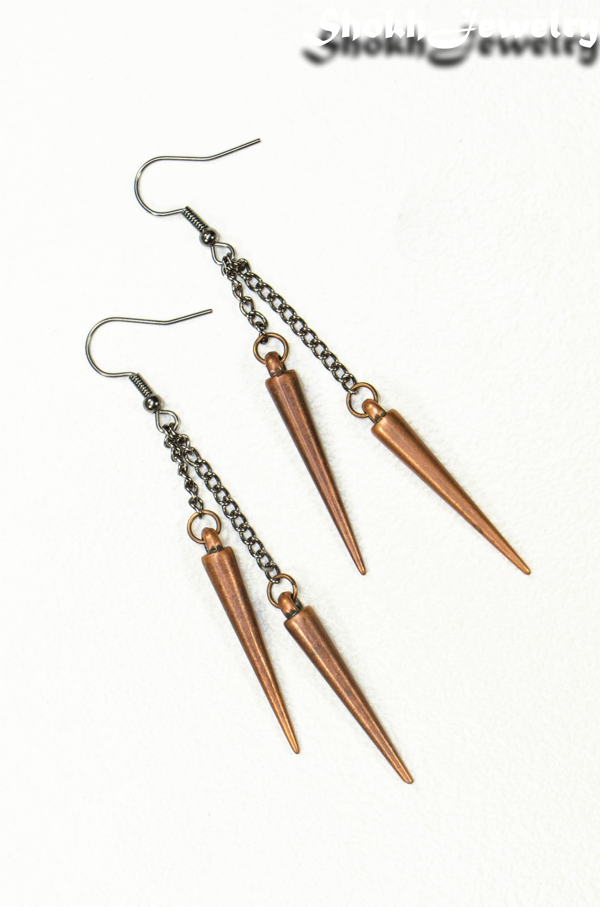 Top view of Long chain and antique copper spike earrings.