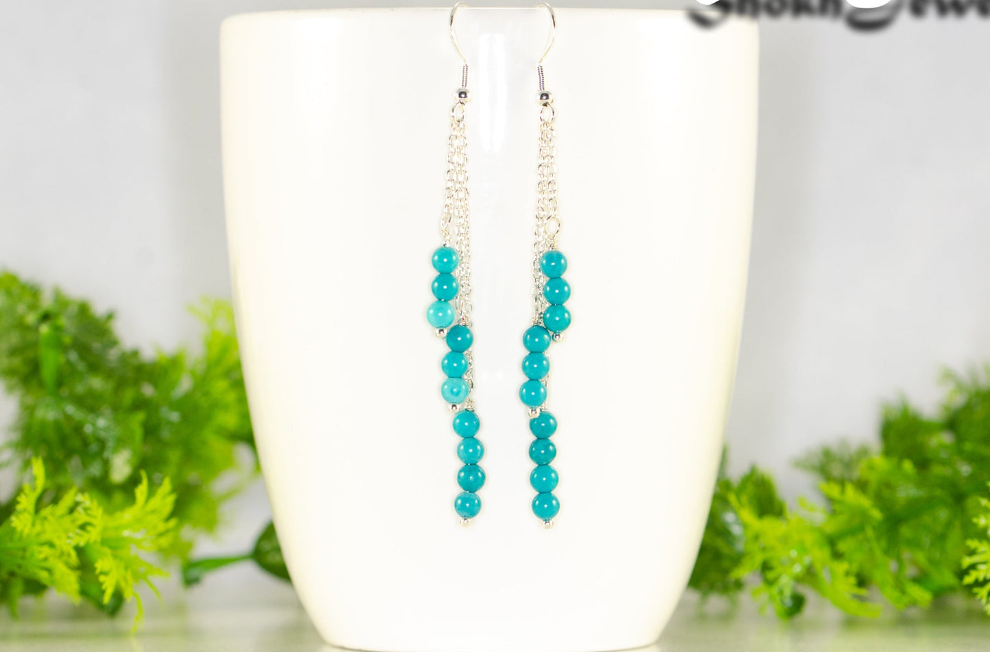 Silver Plated Chain and Turquoise Earrings displayed on a coffee mug.