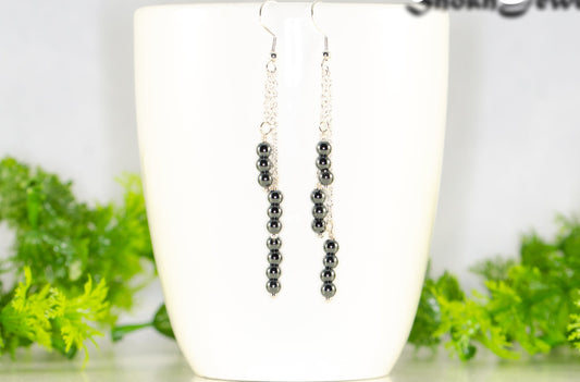 Silver Plated Chain and Natural Hematite Earrings displayed on a coffee mug.