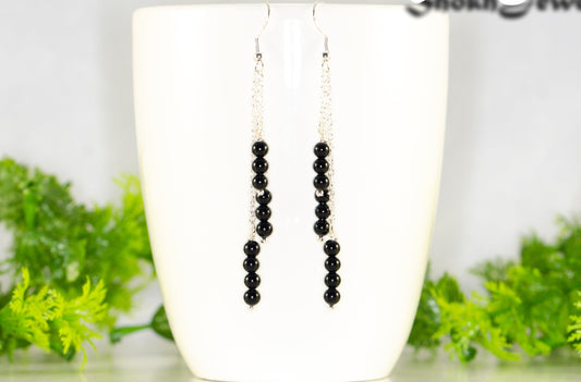 Silver Plated Chain and Black Onyx Stone Earrings displayed on a coffee mug.