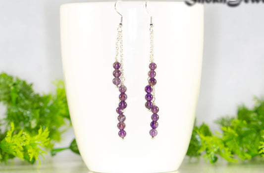 Silver Plated Chain and Amethyst Crystal Earrings displayed on a coffee mug.