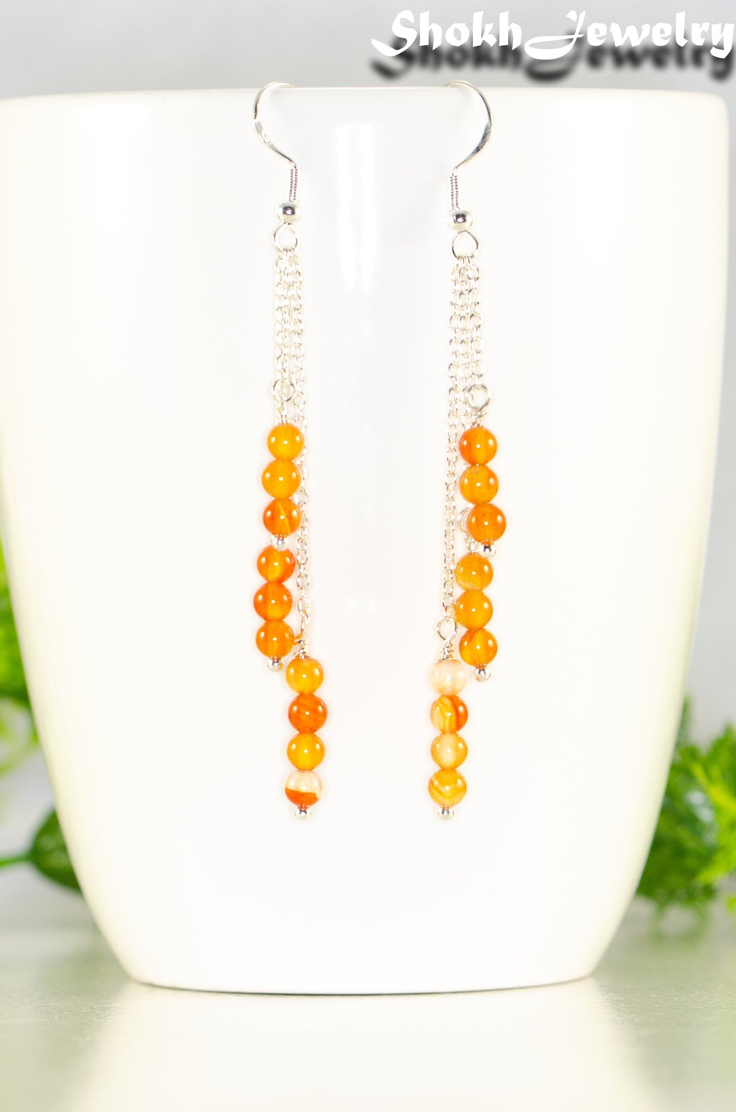 Close up of Silver Plated Chain and Carnelian Crystal Earrings.