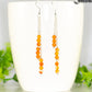 Silver Plated Chain and Carnelian Crystal Earrings displayed on a coffee mug.