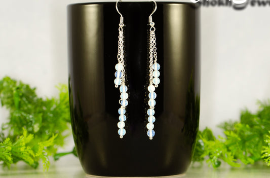 Silver Plated Chain and White Opal Crystal Earrings displayed on a coffee mug.