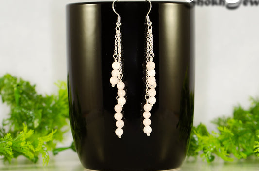 Silver Plated Chain and Rose Quartz Crystal Earrings displayed on a coffee mug.