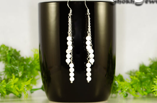 Silver Plated Chain and White Howlite Earrings displayed on a coffee mug.