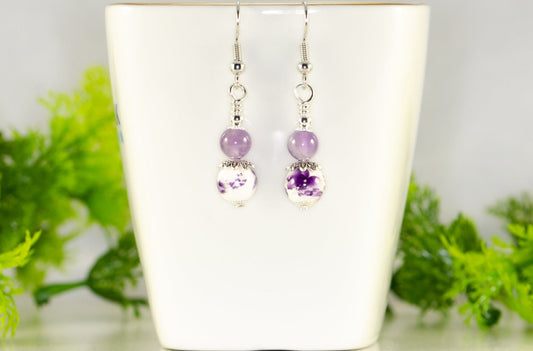 Small Floral Ceramic Bead and Amethyst Earrings displayed on a tea cup.