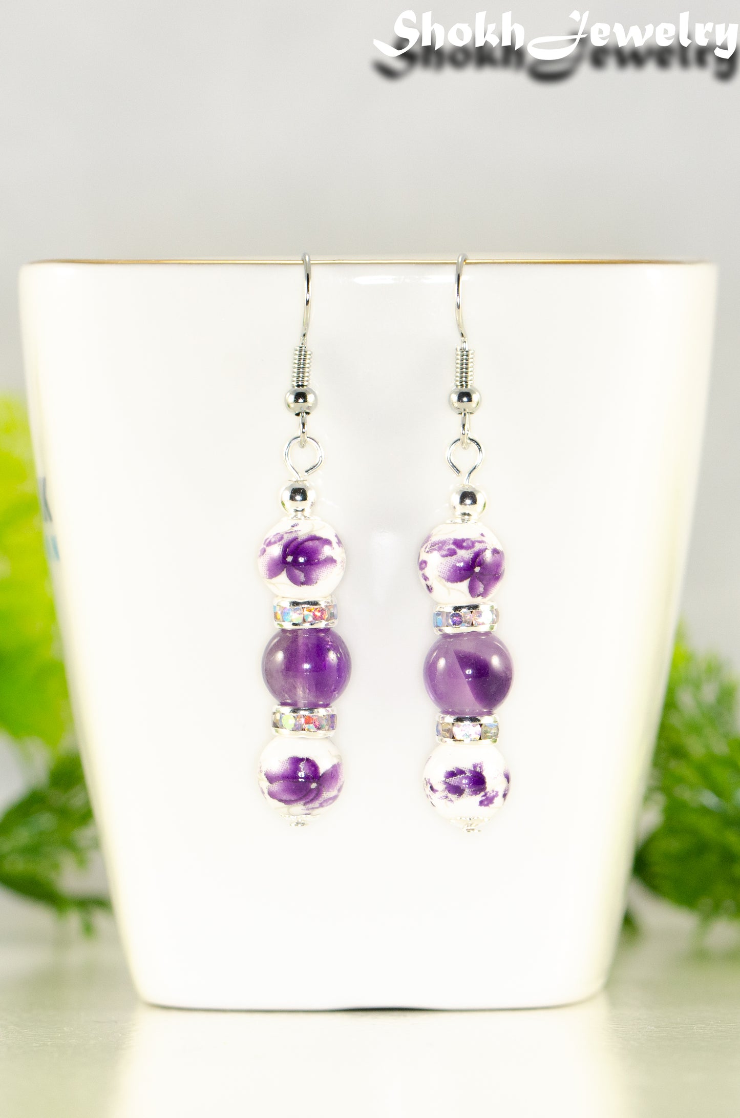 Close up of Long Floral Ceramic Bead and Amethyst Earrings.