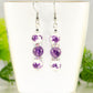 Long Floral Ceramic Bead and Amethyst Earrings displayed on a tea cup.