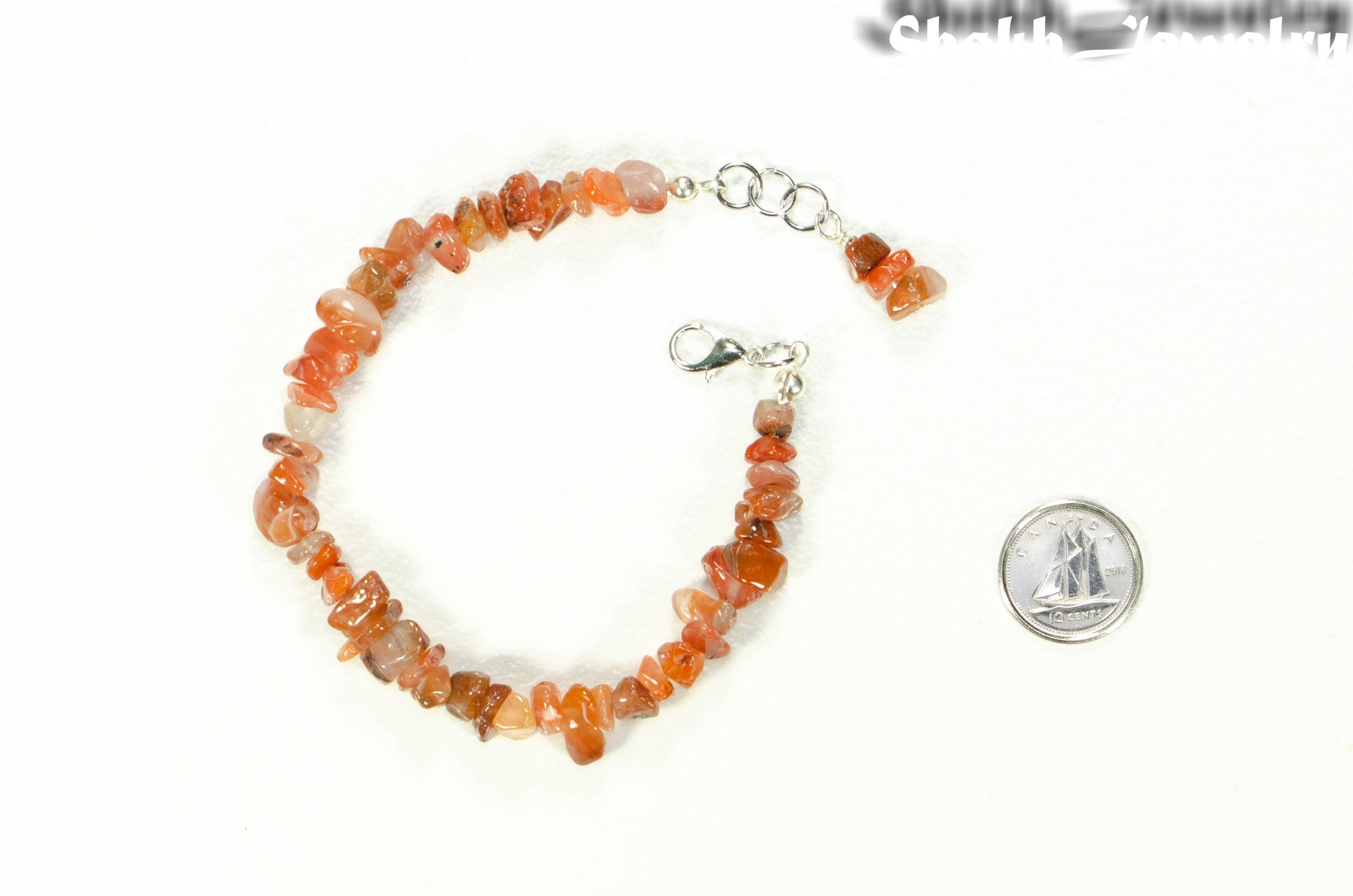 Natural Carnelian Crystal Chip Bracelet beside a dime.