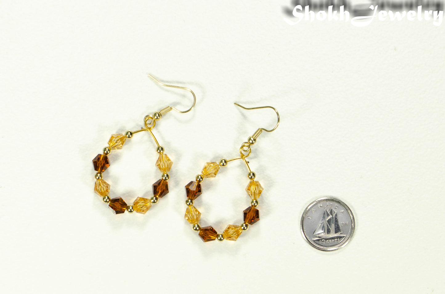 Amber and Brown Glass Crystal Hoop Earrings beside a dime.