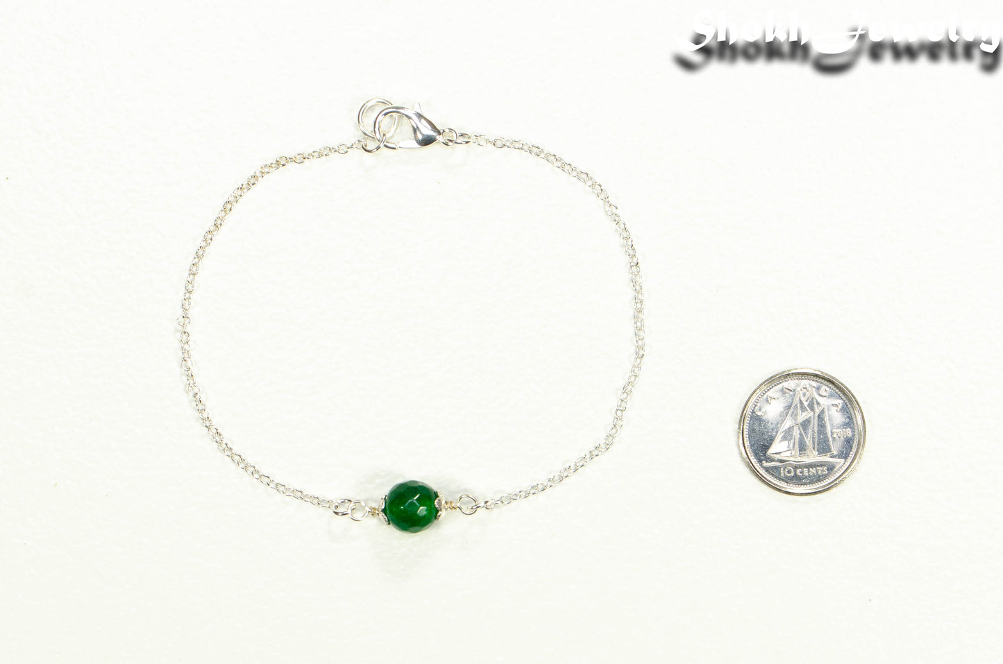 Minimal Green Emerald Bracelet beside a dime.