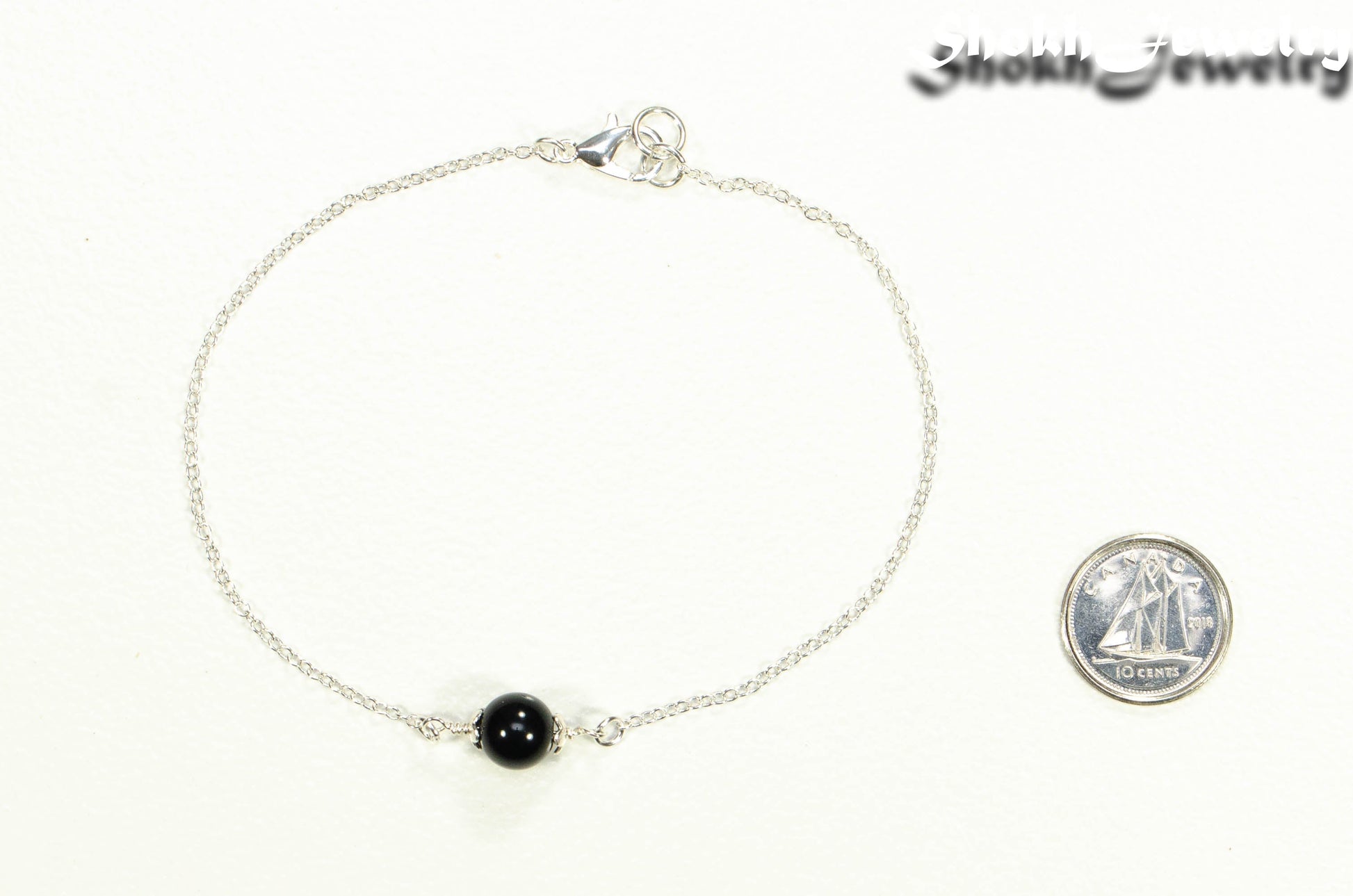 Minimal Black Obsidian Bracelet beside a dime.