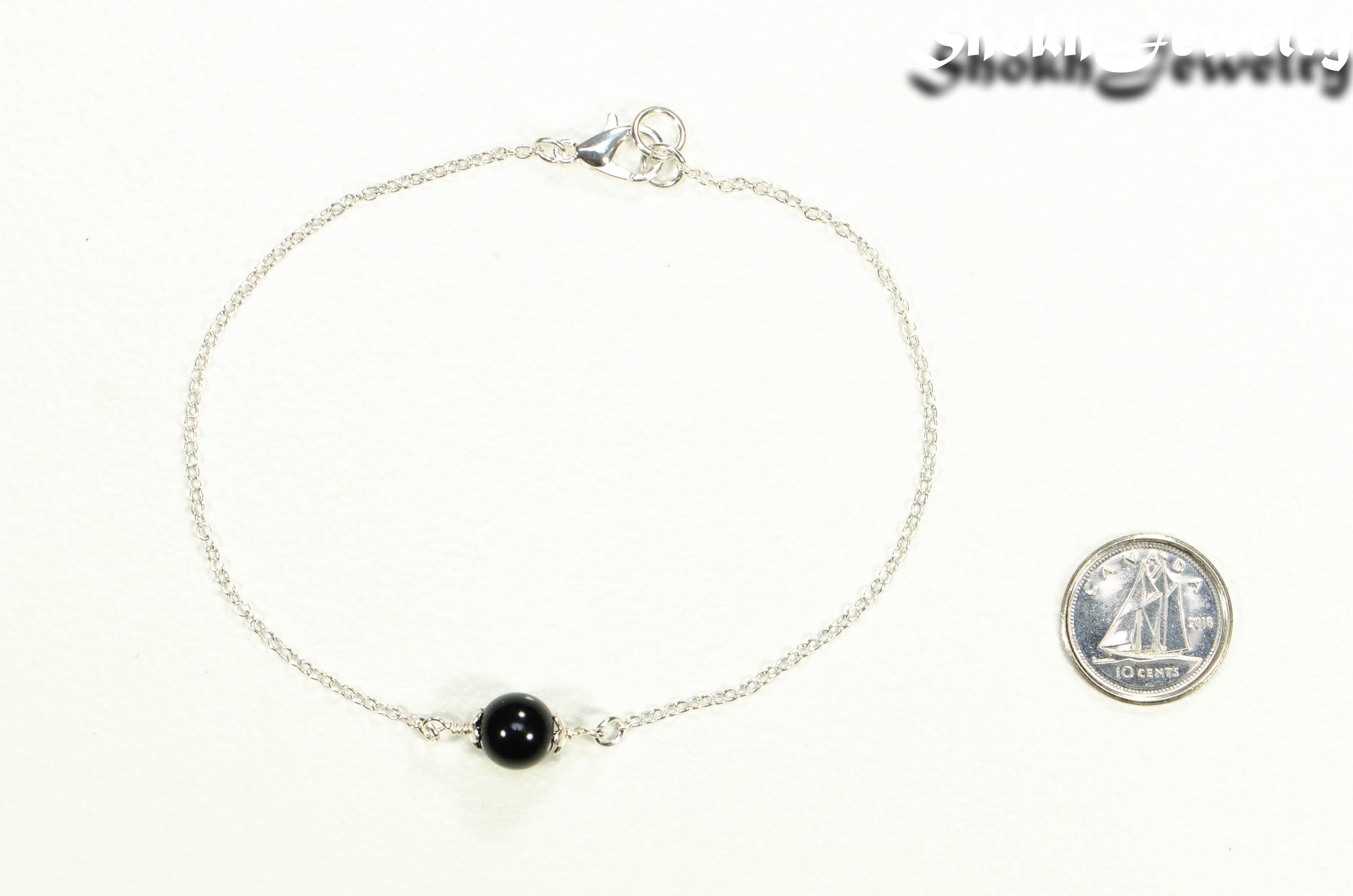 Minimal Black Onyx Bracelet beside a dime.