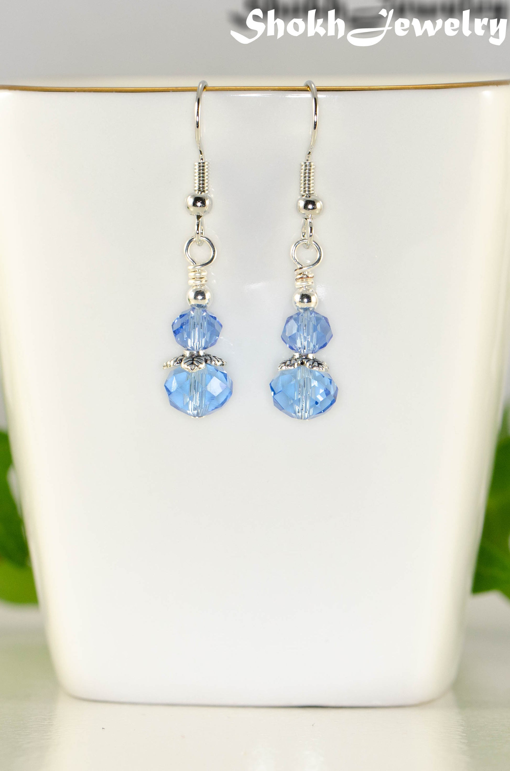 Close up of Small Light Blue Glass Bead Dangle Earrings.