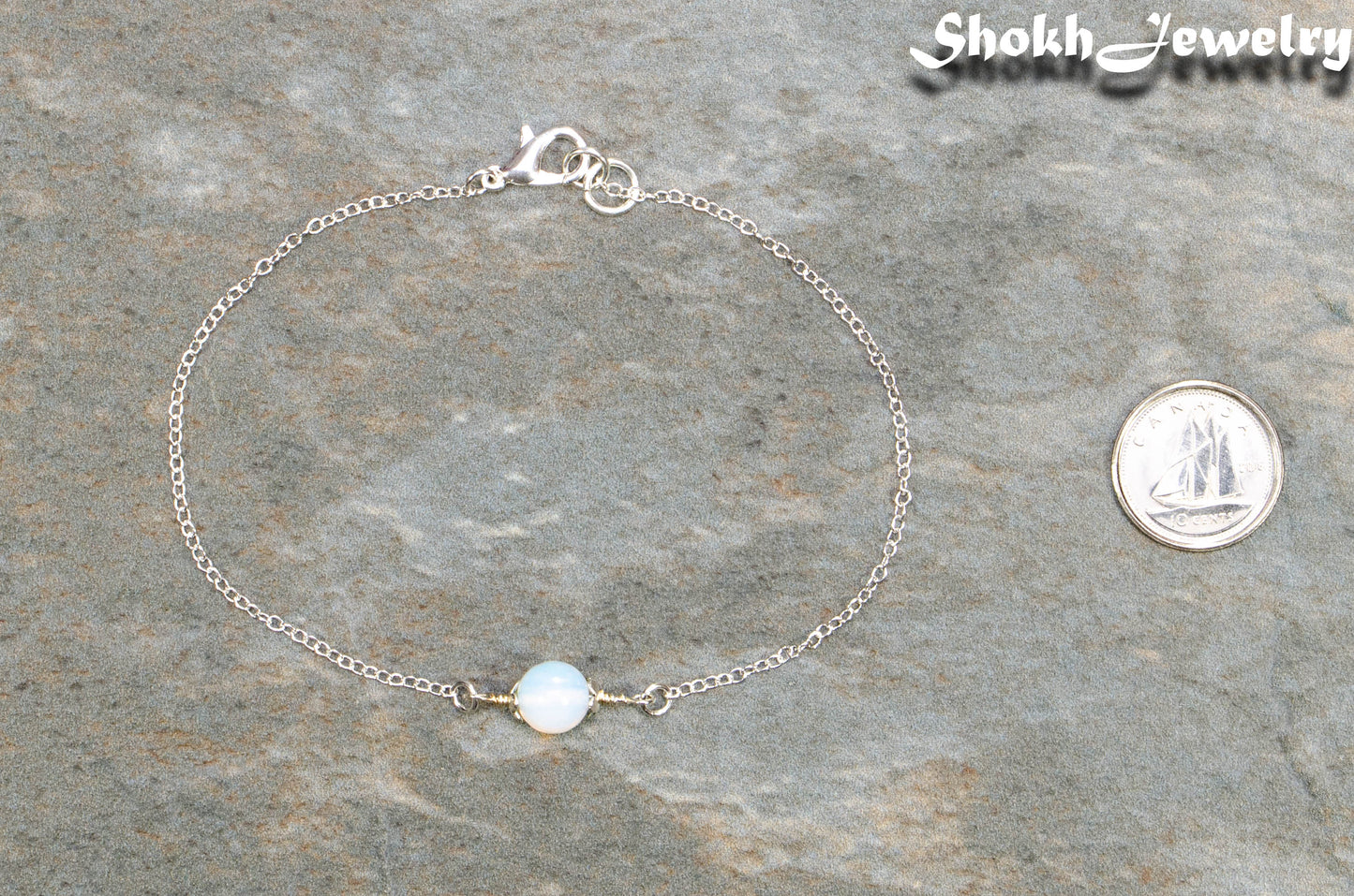 Minimal White Opal Bracelet beside a dime.