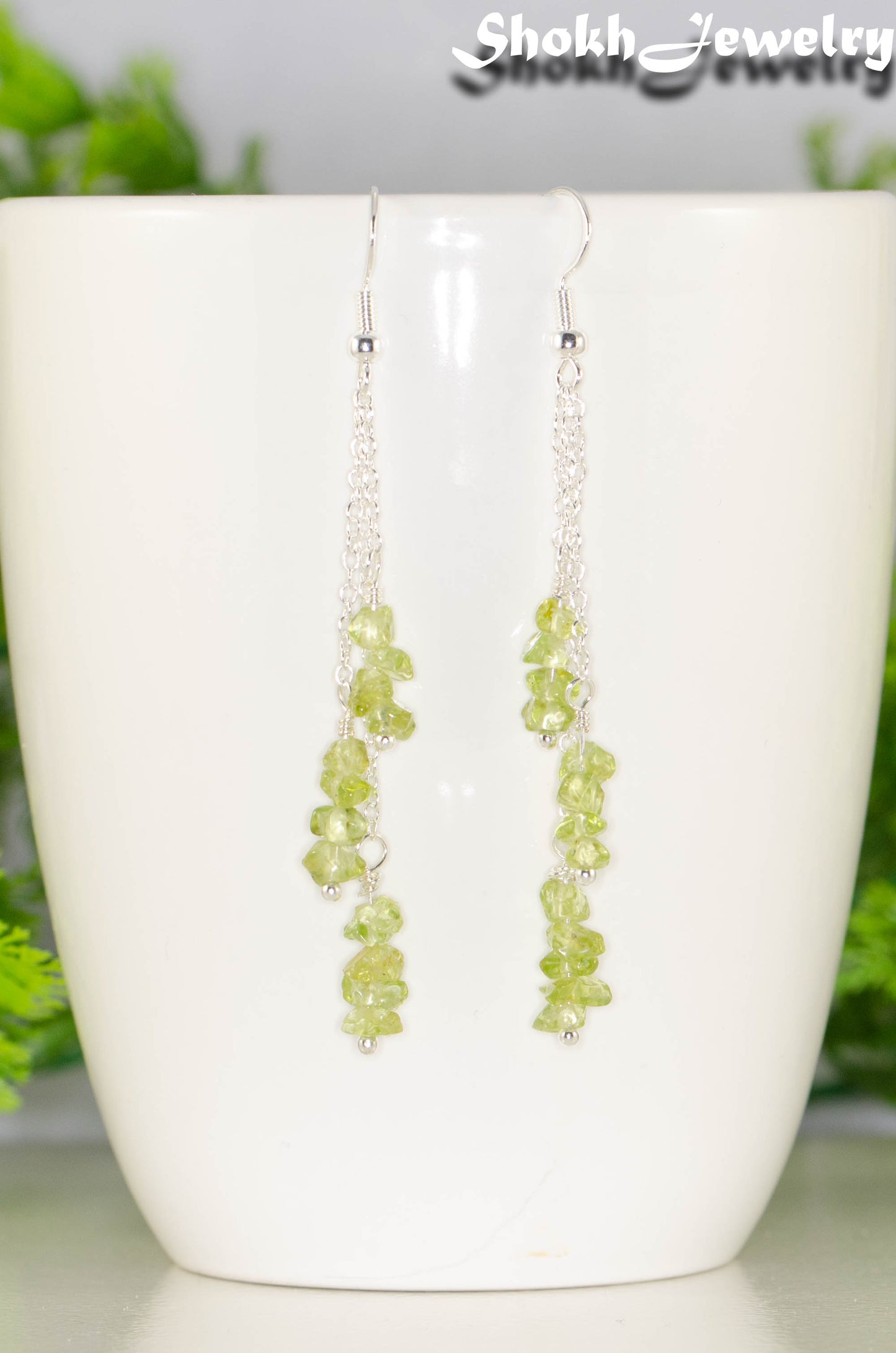 Close up of Long Silver Plated Chain and Peridot Chip Earrings.
