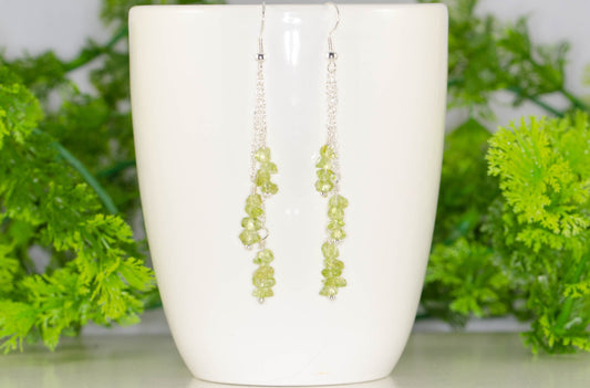 Long Silver Plated Chain and Peridot Chip Earrings displayed on a coffee mug.